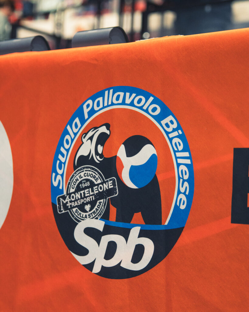 dettaglio divisa arancione con logo di Scuola Pallavolo Biellese Monteleone Trasporti
