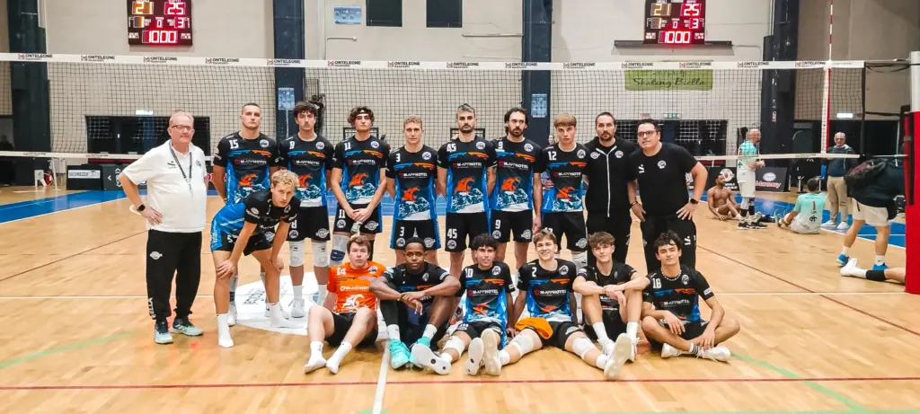 squadra di pallavolisti Serie B Ilario Ormezzano SPB in posa in divisa con staff in campo al PalaPajetta di Biella