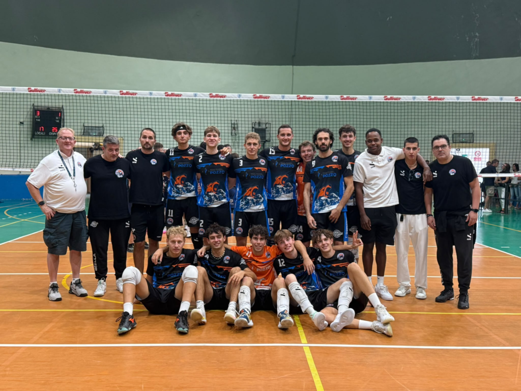 squadra di pallavolisti serie b ilario ormezzano della scuola pallavolo biellese in posa in divida con lo staff in campo di pallavolo